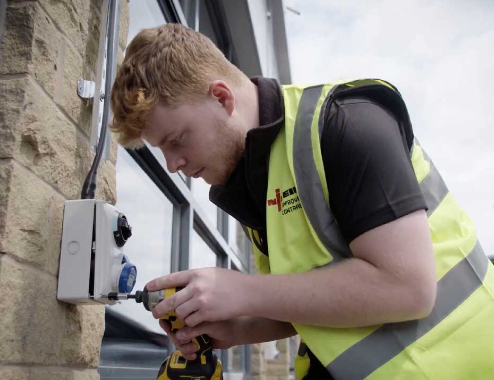 One of the expert electricians at CTE Electrical Contractors fitting an Electric Vehicle charging point to a Yorkshire home.