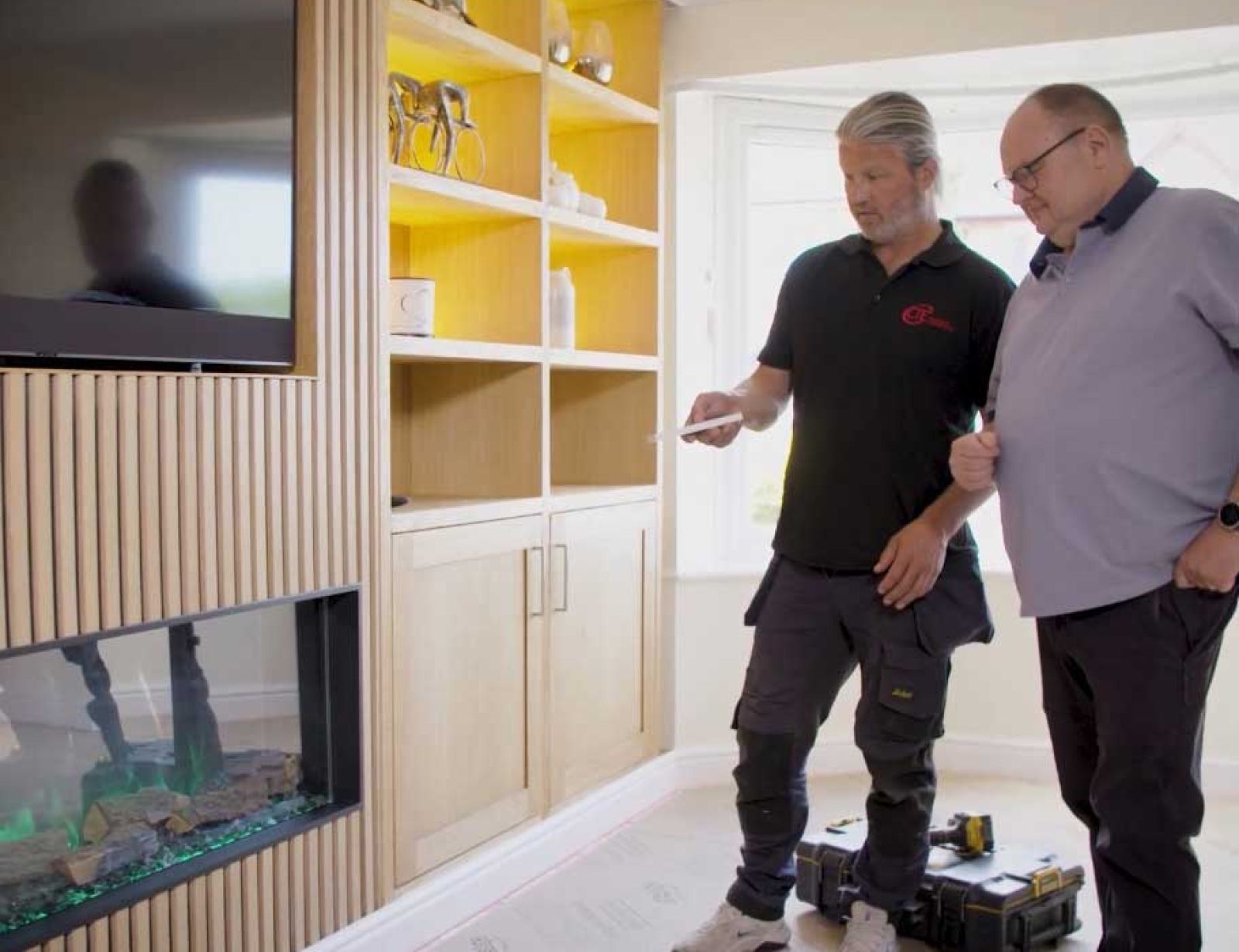 One of the expert electricians at CTE explaining the new living room heating controls to a customer who has upgraded their Yorkshire home.
