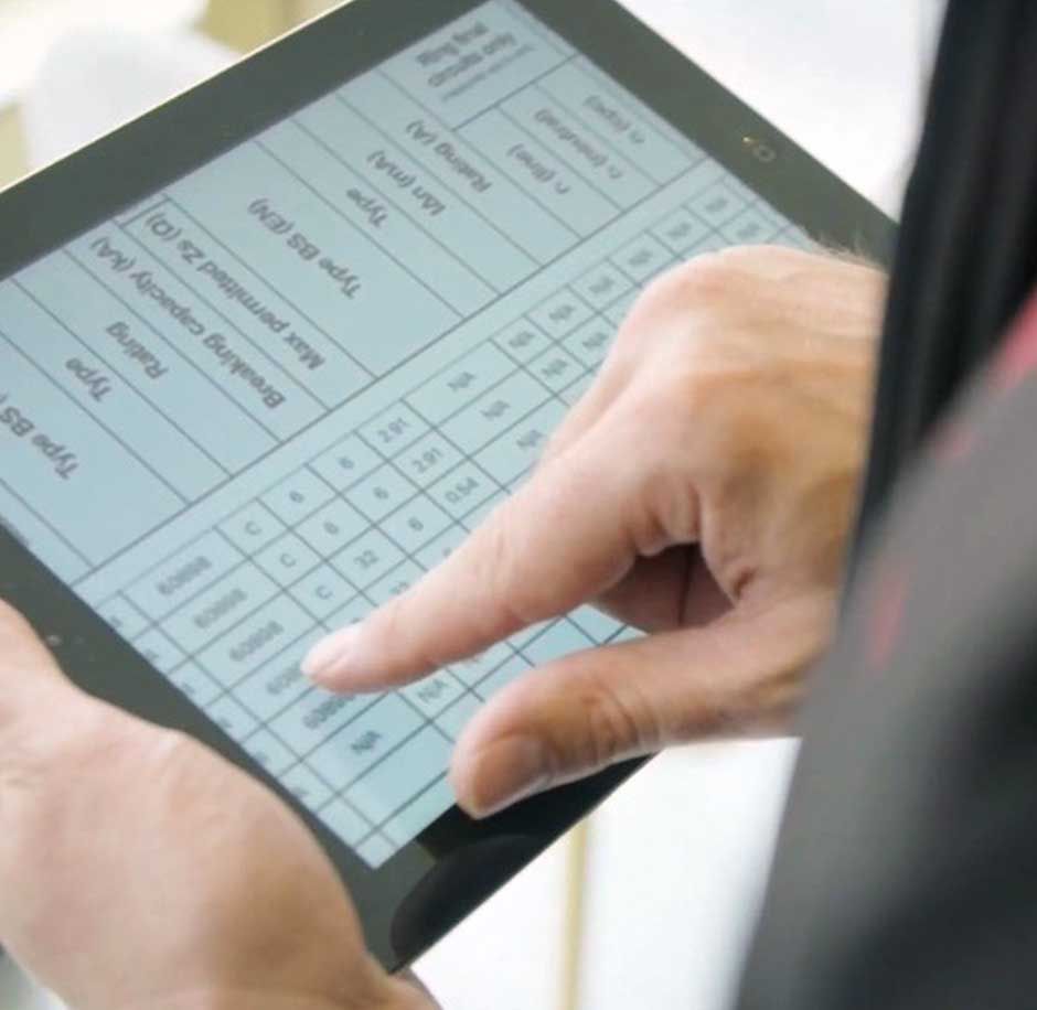 An expert electrician at CTE going over the energy efficiency of a Rotherham business using software on a tablet